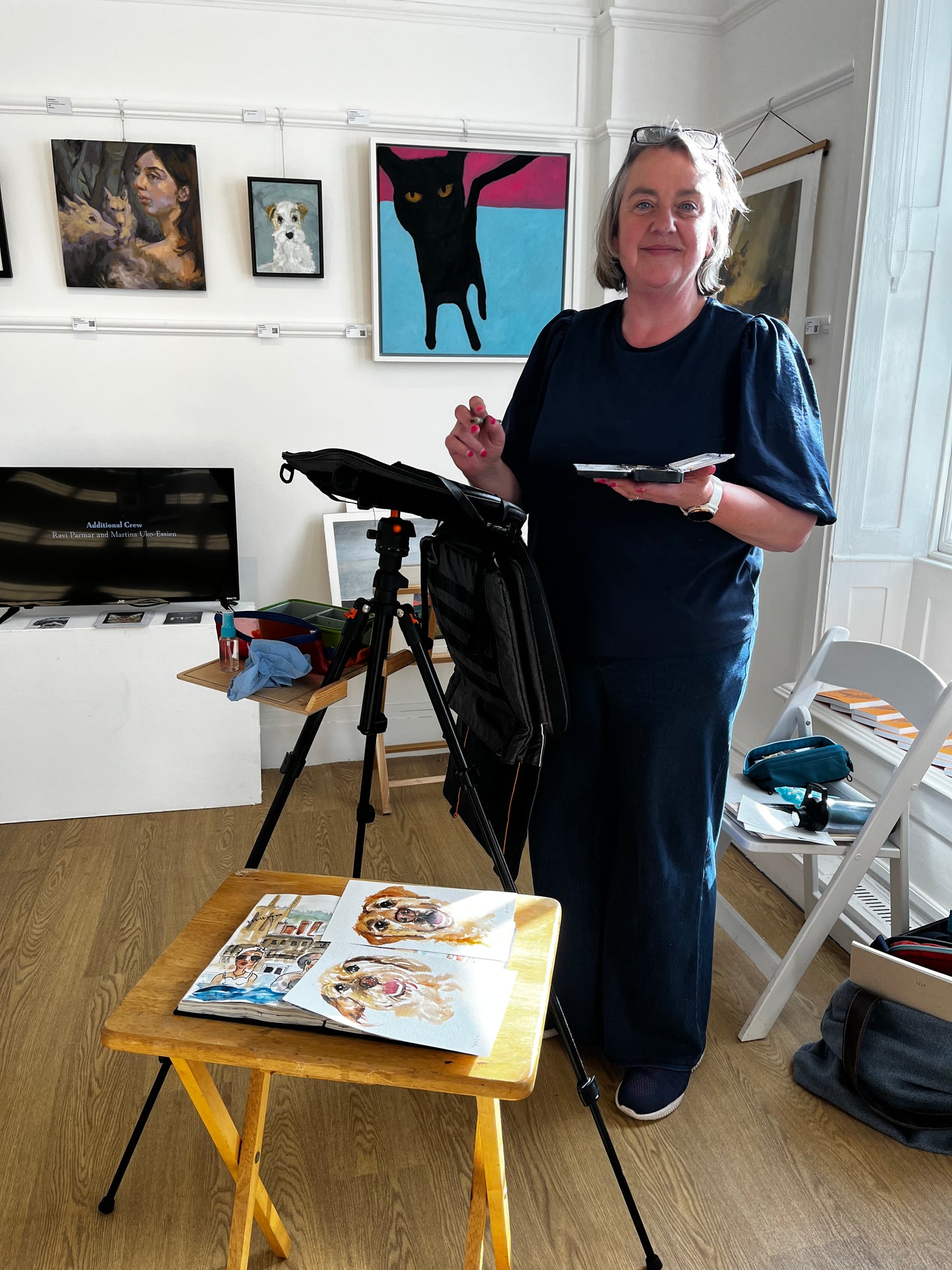 Photo of Jo Scott painting live dog paintings at a  Dog Charity event in an art gallery
